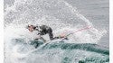 A surfer performs a Throwing The Fins Out maneuver